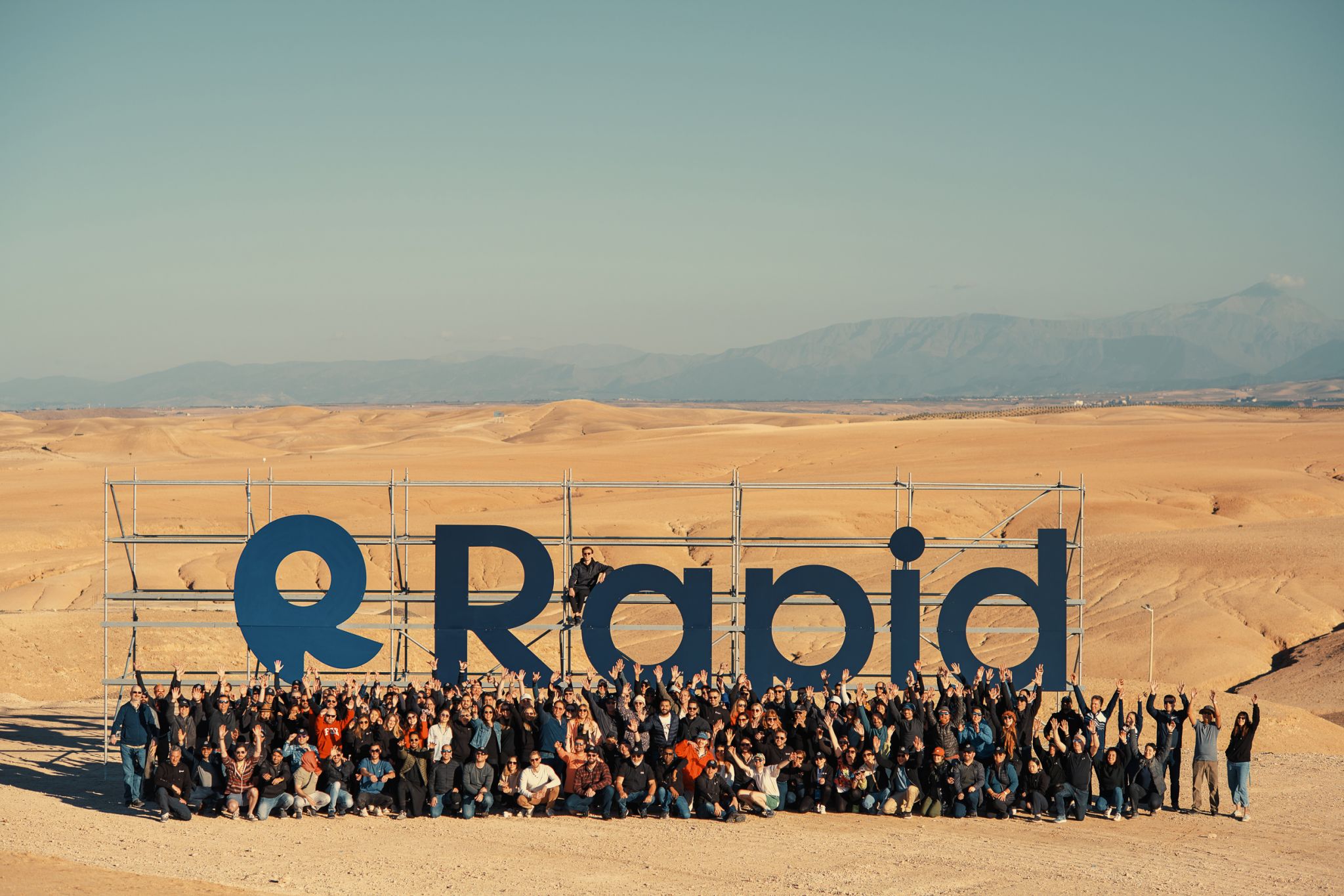 Rapid team members infront of a large billboard saying Rapid